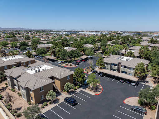 A parking lot in front of a building with a clear blue sky.
