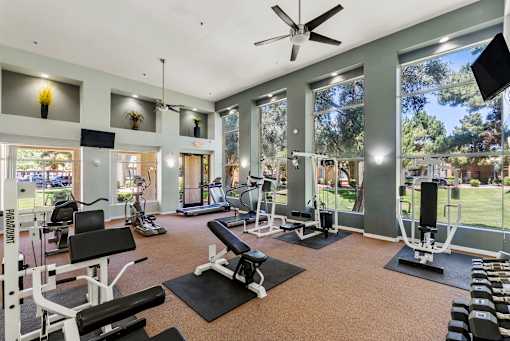 A spacious gym with a variety of equipment and a view of the outdoors.