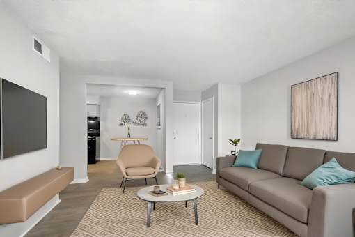 A living room with a grey couch, a brown chair, and a brown bench.