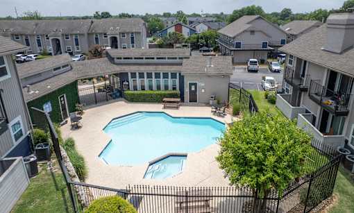 A swimming pool in a residential area surrounded by houses.