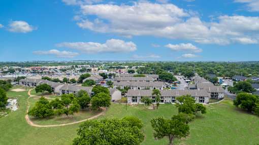 A bird's eye view of a residential area with houses and greenery.