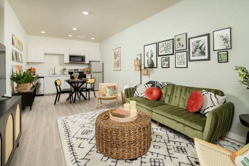 A living room with a green couch and a wicker table.