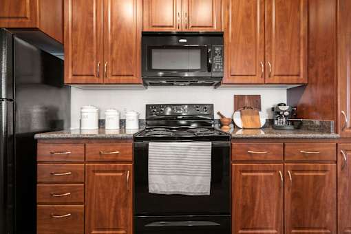 A kitchen with wooden cabinets and a black stove top oven.
