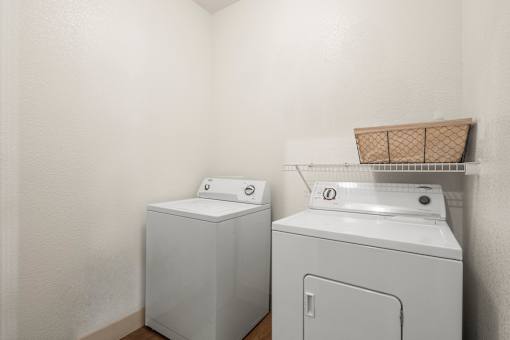 A white washing machine and dryer in a laundry room.