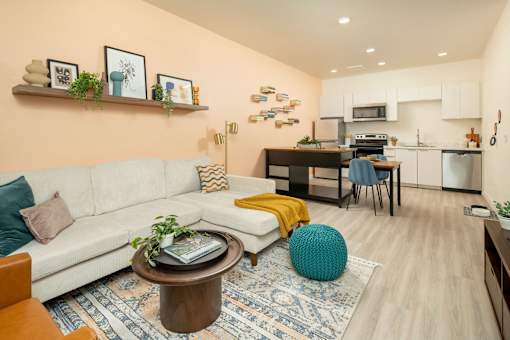 A living room with a white couch and a coffee table with a plant on it.