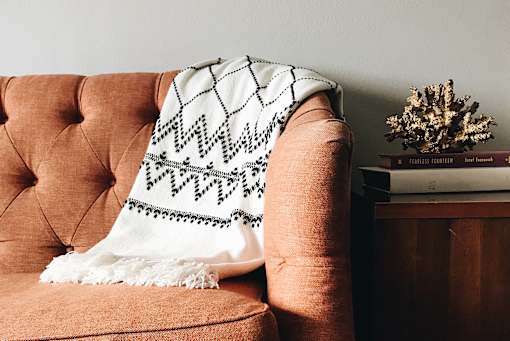 A living room with a couch, a chair, a coffee table, and a television.