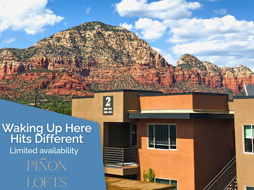 A Pinon Lofts sign is displayed in front of a modern house with a mountain in the background.