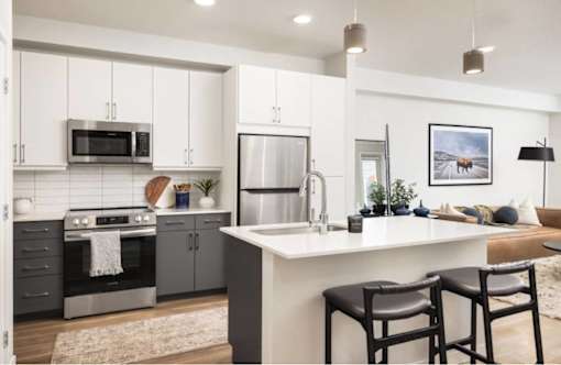A modern kitchen with a large island and bar stools.
