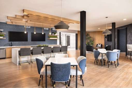 A modern dining room with a long table and chairs.