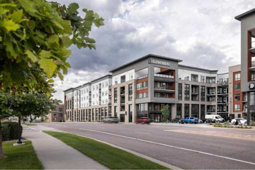 A street view of a residential area with apartment buildings.