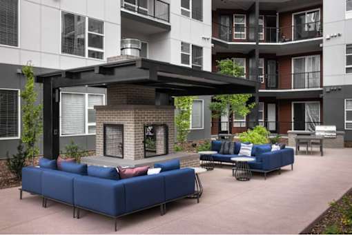 A blue couch is in the middle of a courtyard.