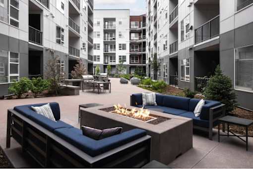 A patio with a fire pit and seating area.