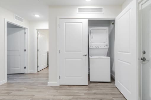 A white door is open to a small laundry room.