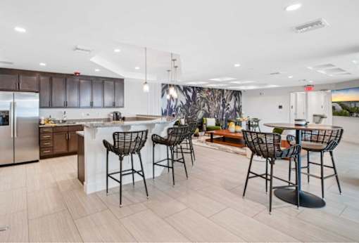 A kitchen with a bar area and chairs.