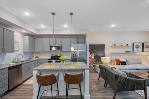 A modern kitchen with a large island and bar stools.