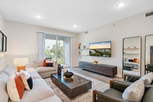 A modern living room with a grey sofa, a wooden coffee table, and a large painting on the wall.