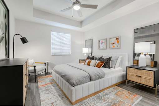 A bedroom with a bed, nightstand, and a rug.
