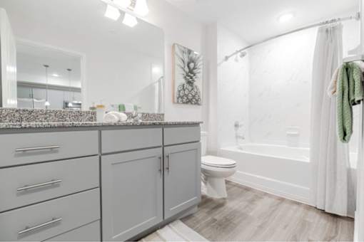 A bathroom with a white tub, toilet, and sink.