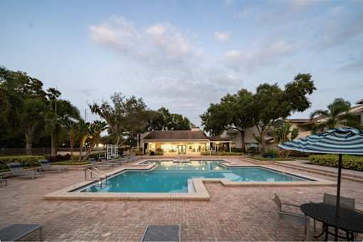 A backyard with a pool and patio furniture.