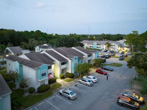 A parking lot with cars and apartment buildings in the background.