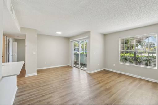 A spacious room with wooden floors and white walls.