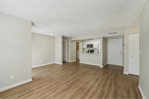 A room with wooden flooring and white walls.