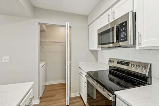 A kitchen with a black microwave and stove top oven.
