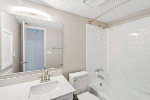 A white bathroom with a sink, toilet, and bathtub.