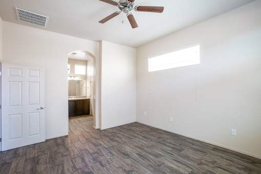 A room with a ceiling fan and a door.
