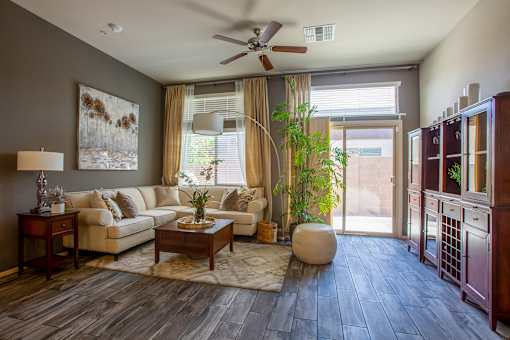 A living room with a white couch, a coffee table, and a ceiling fan.
