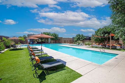 A pool with chairs around it on a sunny day.