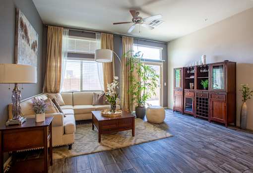 A living room with a couch, a coffee table, and a ceiling fan.
