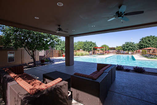 A patio with a pool and furniture.
