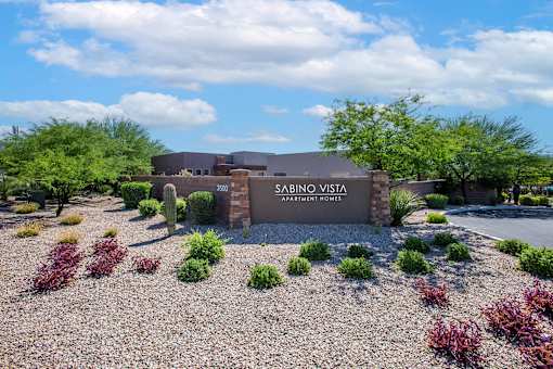 The image shows a building with the name "SABINO VISTA APARTMENT HOMES" on it.