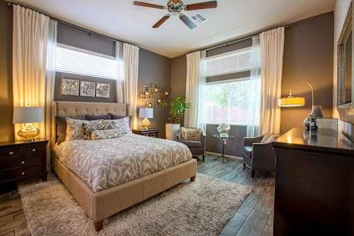 A bedroom with a large bed and a ceiling fan.