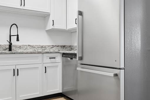 A kitchen with a white fridge and cabinets.