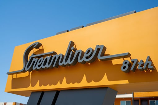 A yellow sign with the word "Streamliner" and the number 87th.