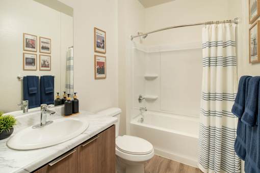 A white bathroom with a toilet, sink, and shower.
