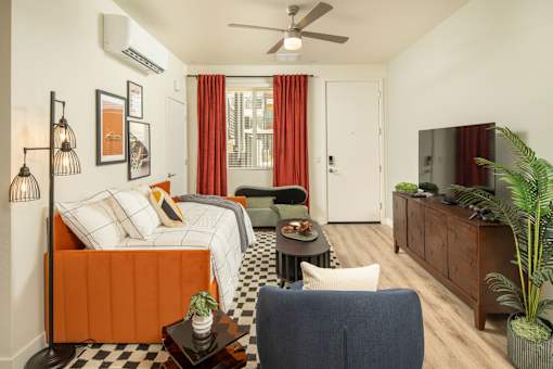 A living room with a bed, a chair, and a television.