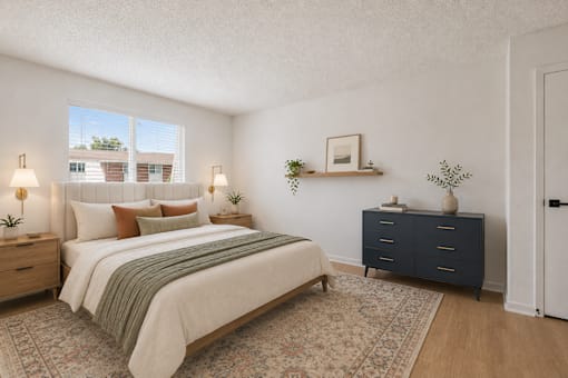 A bedroom with a bed, nightstand, and dresser.