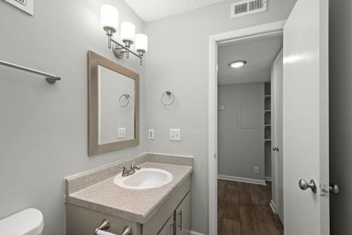 A bathroom with a sink, mirror, and toilet.