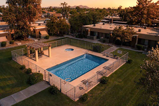 A swimming pool surrounded by a fence in a backyard.
