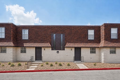 A row of houses with a red brick wall and a black door.