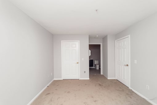 a bedroom with two doors and a carpeted floor at Ardenwood Apartments, North Haven, Connecticut