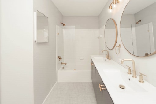a white bathroom with a shower and a sink and a mirror at Ardenwood Apartments, North Haven, 06473