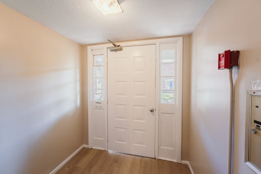 an empty room with a white door and a refrigerator at BAY SHORE APARTMENTS, EAST HAVEN, 06512