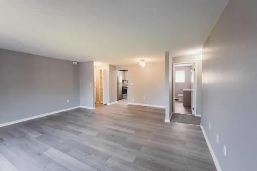 a renovated living room with a wood floor and white walls at BAY SHORE APARTMENTS, EAST HAVEN, CT, 06512