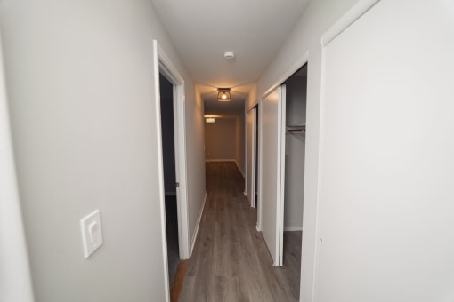 a pass through hallway in a new home with white walls and wood floors  at Enclave West Hartford / Parc West, Connecticut, 06110
