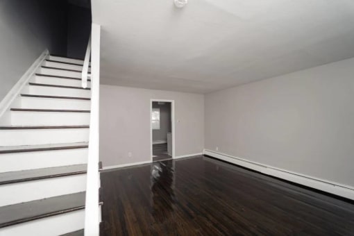 an empty living room with stairs and a white staircase at Encore 99, East Haven, CT, 06512