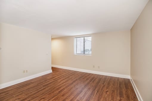 an empty living room with wood flooring and a window at Retro 511 Apartments, West Haven, CT